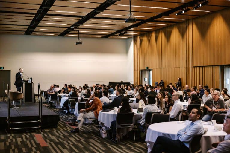 Large conference room with attendees listening to a speaker at the VFLI Conference 2026.