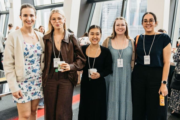 Group of diverse women smiling at the VFLI Conference 2026 in a modern venue.