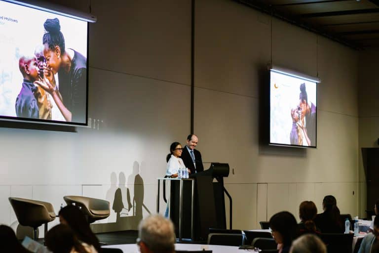 Speakers presenting at the Vision For Life conference with audience in the background.